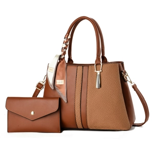 Detail of two-piece brown leather tote bag with woven texture and matching wallet