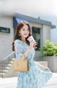 Elegant champagne tote bag with litchi texture and heart pendant shown on floral dress model
