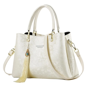 Sac fourre-tout beige à fleurs gaufrées, détails dorés, pompons et bandoulière amovible