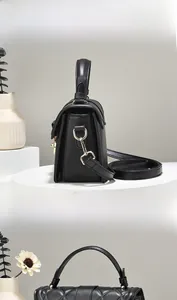 Détails d'un sac à main en cuir matelassé noir avec fermoir doré et bandoulière