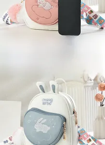 Detail view of cartoon rabbit backpack with colorful printed straps and plush charm
