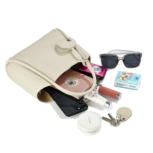 Sac à main en cuir blanc cassé de grande capacité avec objets du quotidien en vue de haut