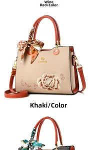 Detail of elegant khaki leather handbag with floral embroidery and printed silk scarf