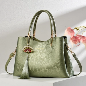 Elegant emerald green Chinese style handbag with embossed floral texture and tassel charm
