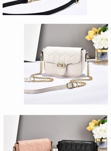 Detail of quilted diamond pattern and interlocking gold metal clasp on luxury shoulder bag