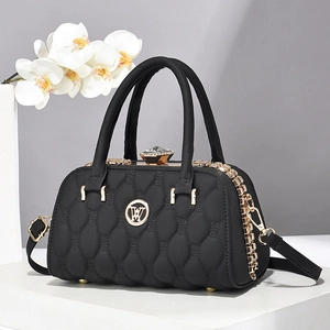 Sac à main noir matelassé avec fermoir cristal et bandoulière sur socle blanc