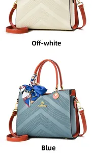 Detail of embossed tote bags in beige and blue with contrasting orange handles