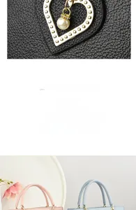 Detail of luxury lychee texture leather handbag with heart charm and pearl pendant