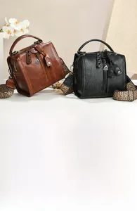 Detail of vintage Boston bags in brown and black with ethnic style woven shoulder straps