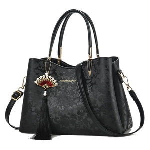 Elegant black embossed floral handbag with traditional Chinese fan tassel and top handle