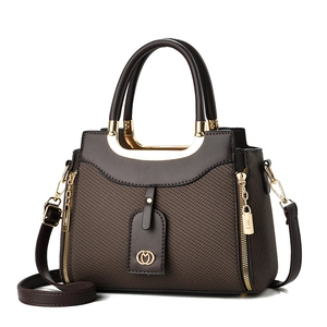 Deep brown woven leather tote bag with gold circular handles and decorative zipper details