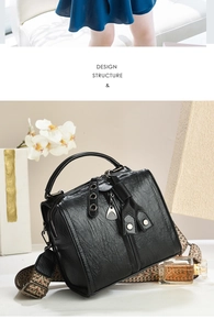 Detail of vintage pleated black leather texture and ethnic jacquard strap on boston bag