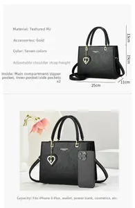 Detailed size and capacity view of black PU leather handbag with gold heart pendant