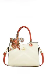 Close-up of embossed V-pattern handbag with orange handles and silk scarf detail