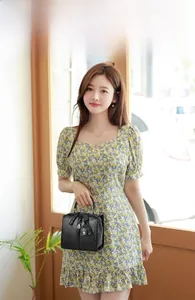 Litchi pattern black leather Boston bag held by model in floral dress