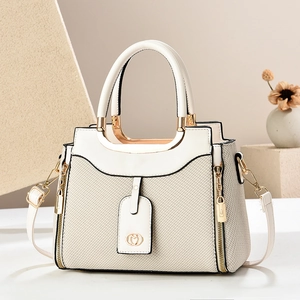 Chic beige woven leather handbag with a unique semicircular metal handle and shoulder strap