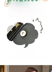 Close-up of black leather bag with white contrast stitching and gold magnetic hardware