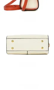 Detail view of the cream leather bag showing the side profile and base with gold studs
