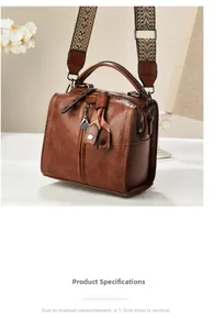 Brown vintage leather boston bag featuring a woven strap and decorative charm details