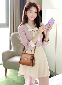 Brown leather crossbody bag with gold buckle and adjustable strap shown on model