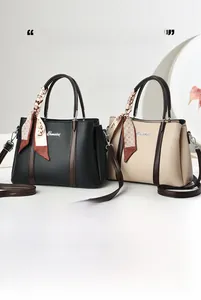 Dettaglio di borse tote in pelle litchi con manici a contrasto e foulard di seta floreale