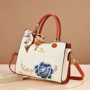 Elegant white leather handbag with blue peony embroidery and orange trim handles