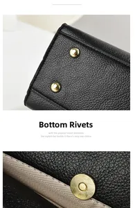 Detail of black lychee grain leather handbag with gold protective base studs and magnetic buckle