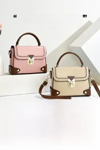 Detailed view of pink and beige retro shoulder bags with brown trim and gold hardware