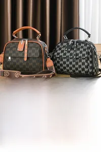 Détail de sacs Boston avec imprimé monogramme, larges bandoulières jacquard et rivets