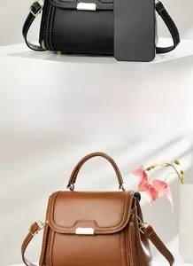 Detail of vintage square crossbody bags in black and caramel with contrast stitching