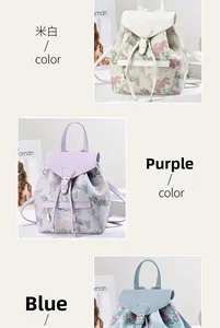 Dettaglio di zaini ricamati a fiori in bianco, viola e blu con fibbie in metallo
