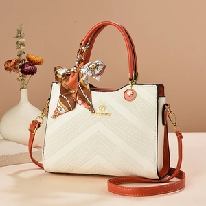 Fashionable embossed tote bag in beige and orange with a silk scarf decoration