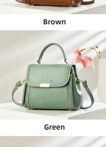 Detail view of structured green and brown leather handbags with metallic buckle and strap