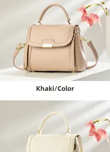 Detail of minimalist khaki and cream white leather crossbody bags with gold hardware