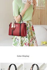 Dettaglio della borsa tote in pelle rossa con elegante foulard e logo in metallo