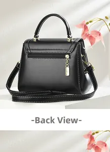 Detail of black crossbody bag back with white stitching and gold zipper pocket