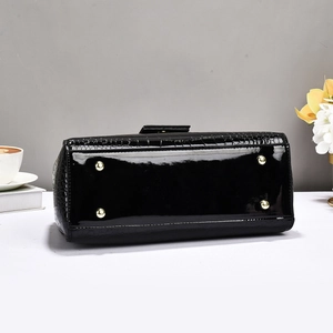 Close-up of black faux-crocodile leather bag base with protective gold metal feet