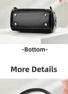 Detail of black leather handbag base featuring four gold studs and white contrast stitching