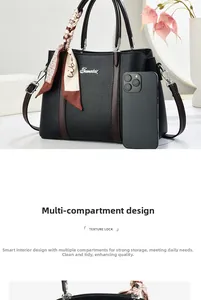 Dettaglio di una borsa in pelle nera con grande capacità e decorazione con sciarpa di seta