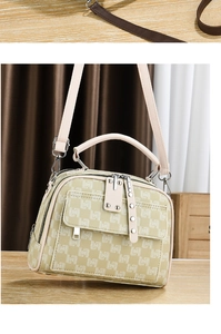 Détail d'un sac bandoulière beige avec motif monogramme et détails de clous argentés