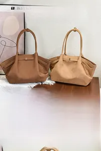 Detail of minimalist tote bags in dark and light brown matte finish with metal clasps