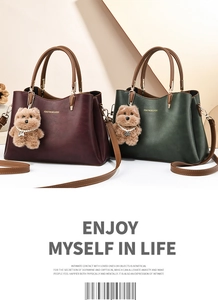 Close-up of stylish leather tote bags with bear charm and elegant gold lettering