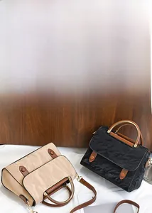 Détail d'un sac plissé vintage avec poignée en métal circulaire et bandoulières en cuir brun
