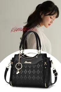 Detail der schwarzen Lederhandtasche mit Rautensteppung und elegantem Perlenanhänger