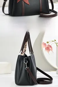 Dettagli della borsa a secchiello in pelle nera con foulard in seta sul manico