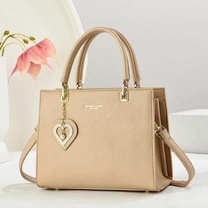 Elegant beige leather tote bag with heart pearl pendant and adjustable shoulder strap