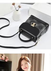 Detail of a vintage contrast plaid handbag with a golden letter clasp and top handle