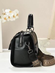 Retro black pillow bag with bohemian shoulder strap shown from a 45-degree angle view