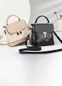 Detailed view of the metal twist lock closure and plaid texture on the stylish crossbody bag