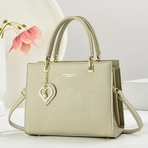 Elegante borsa a mano in pelle verde chiaro con ciondolo di perle e tracolla
